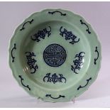 A CHINESE CELEDON GROUND DISH, decorated with stylised bats, 27cm diameter.