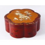 AN EARLY 20TH CENTURY JAPANESE LACQUER BOX AND COVER, of lobed form, the cover onlaid with carved