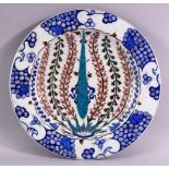 A GOOD LARGE IZNIK POTTERY DISH, the centre painted with flower sprays within a stylised border,