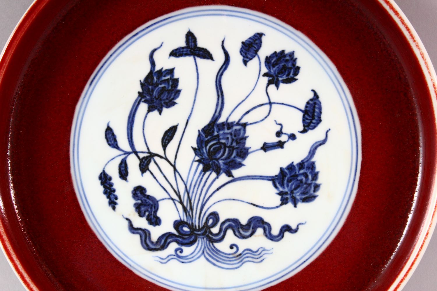 A MING STYLE COPPER RED CIRCULAR PORCELAIN DISH, the central blue and white panel painted with lotus - Image 2 of 5
