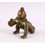 A SMALL EARLY CAST BRONZE INDIAN CROUCHING FIGURE, with inset gold and ruby eyes, 9cm long.