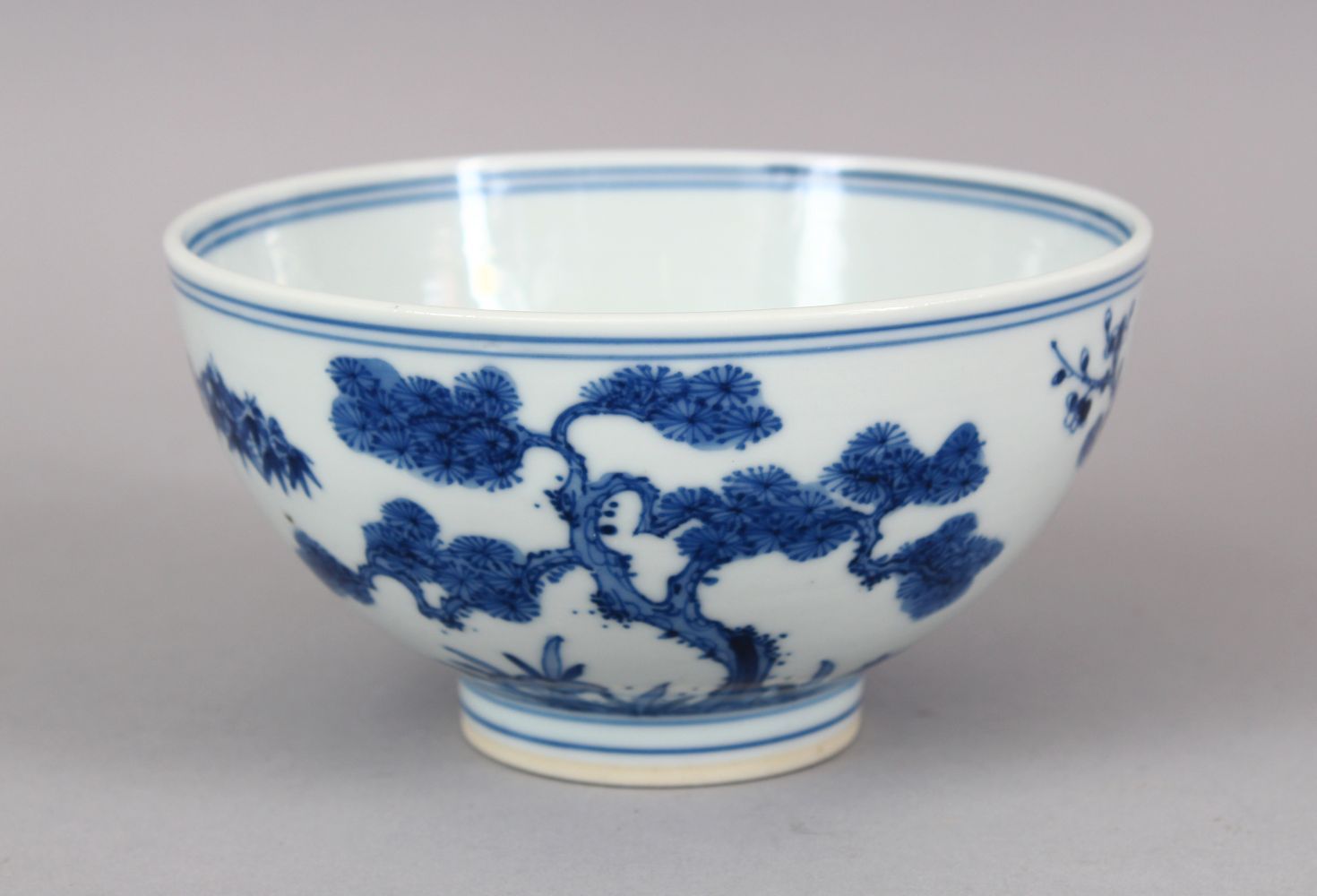 A CHINESE BLUE & WHITE PORCELAIN BOWL, the body with native flora and foliage, the base with a six