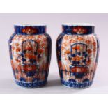 A PAIR OF JAPANESE MEIJI PERIOD IMARI PORCELAIN VASES, with ribbed body, and panel decoration of
