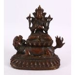 A TIBETAN BRONZE FIGURE OF BUDDHA / DEITY, in a seated position upon a recumbent lion dog, upon a