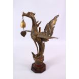 AN INDONESIAN CAST AND GILDED TEMPLE BELL IN THE FORM OF A BIRD standing with outspread wings and