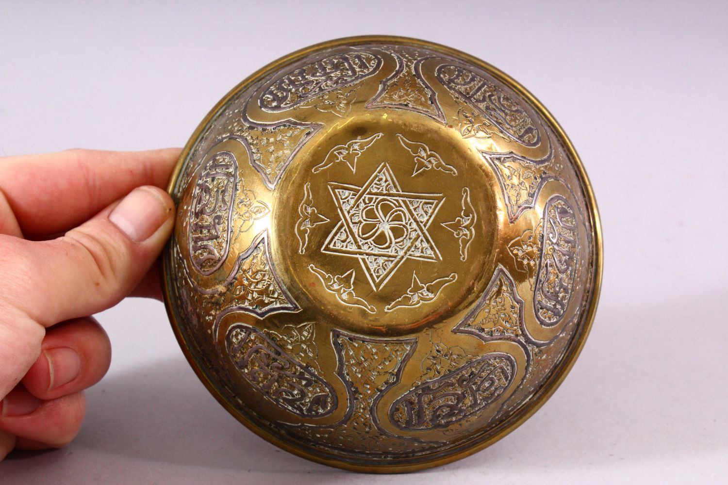 A SMALL ISLAMIC CIRCULAR BRASS BOWL with silver inlaid and engraved decoration, 13cm diameter. - Image 4 of 4