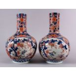 A PAIR OF JAPANESE MEIJI PERIOD IMARI PORCELAIN BOTTLE VASES, decorated with panels of the three