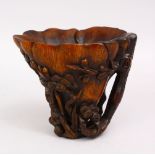 A GOOD LATE 19TH CENTURY CARVED RHINO HORN LIBATION CUP, the body with prunus and blossom, 12cm