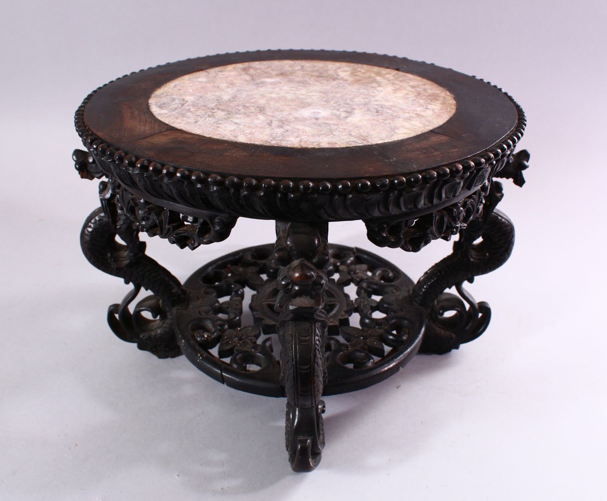 A GOOD CHINESE CARVED HARDWOOD STAND, with inlaid marble top, 22cm high, 30cm diameter.