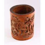 A GOOD CHINESE BAMBOO BRUSH POT, deeply carved with figures in a mountainous landscape, 18cm high.