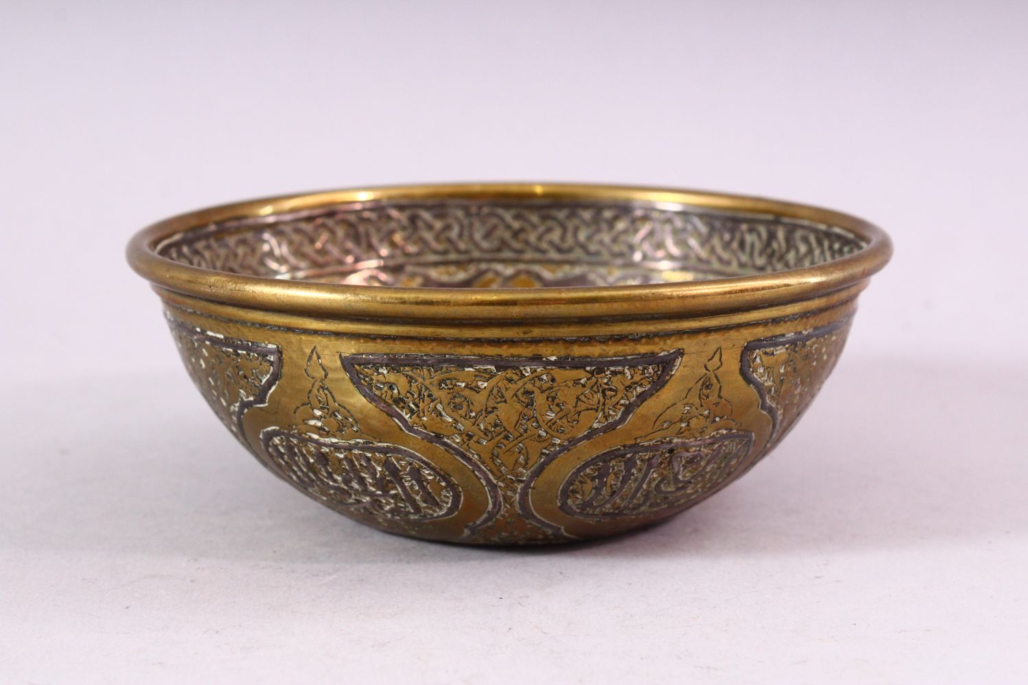 A SMALL ISLAMIC CIRCULAR BRASS BOWL with silver inlaid and engraved decoration, 13cm diameter. - Image 2 of 4