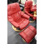 A good Stressless red leather upholstered swivel armchair with matching foot stool.