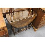 An oak oval drop leaf gate leg table with a drawer to one end.