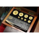 A small mahogany box containing gold weights.