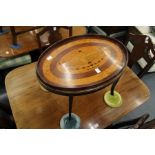 A mahogany and marquetry oval low table inlaid with a classical urn and floral swags.