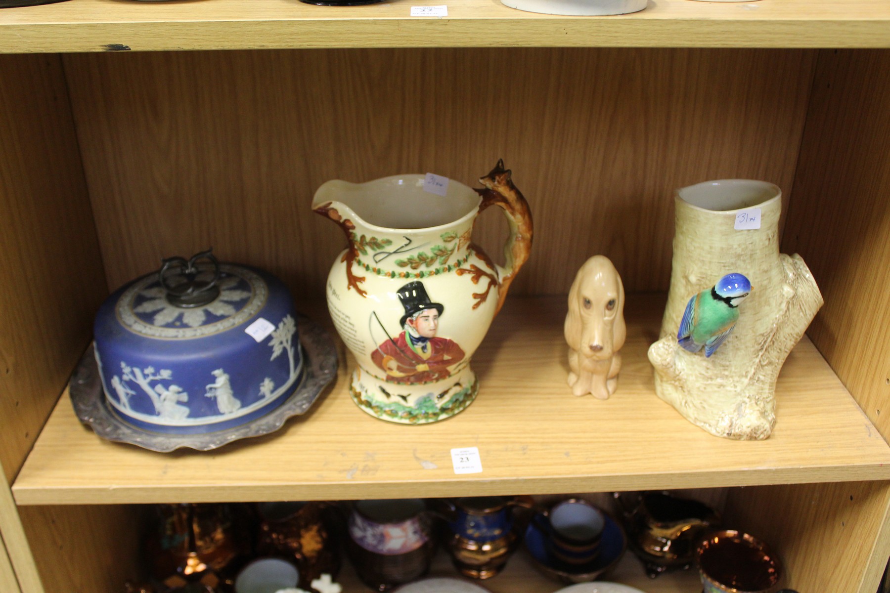 A musical jug, a Jasper ware cheese dome, pottery dog and a naturalistic pottery vase.