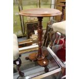 A 20th century mahogany circular occasional table with column support on a trefoil shaped base