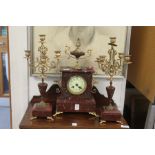 A late 19th century rouge marble and ormolu clock garniture.
