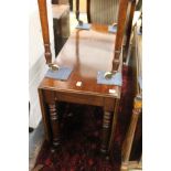 A 19th century mahogany drop leaf gate leg dining table on turned legs.