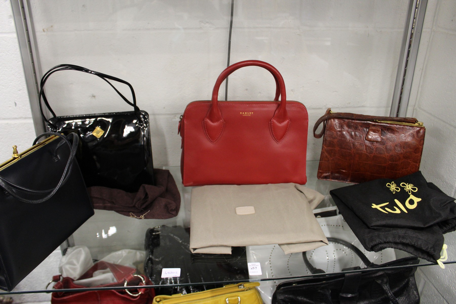 A Radley red leather handbag and three other bags.
