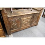 A continental carved oak settle with lifting lid and triple carved panelled front.
