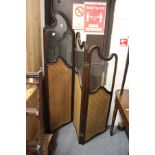 An Edwardian carved mahogany three panel folding dressing screen with part glazed and part