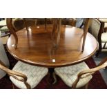 A Victorian mahogany oval tilt top breakfast table on a carved base with four carved curving legs.