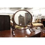 An oval dressing table mirror.