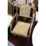 A folding cane seated armchair.