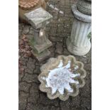 A shell shaped bird bath top together with a classical style pedestal base.