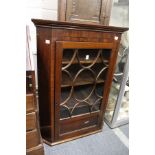 A 19th century mahogany hanging corner cabinet with glazed door.