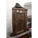 A small oak hanging corner cabinet.