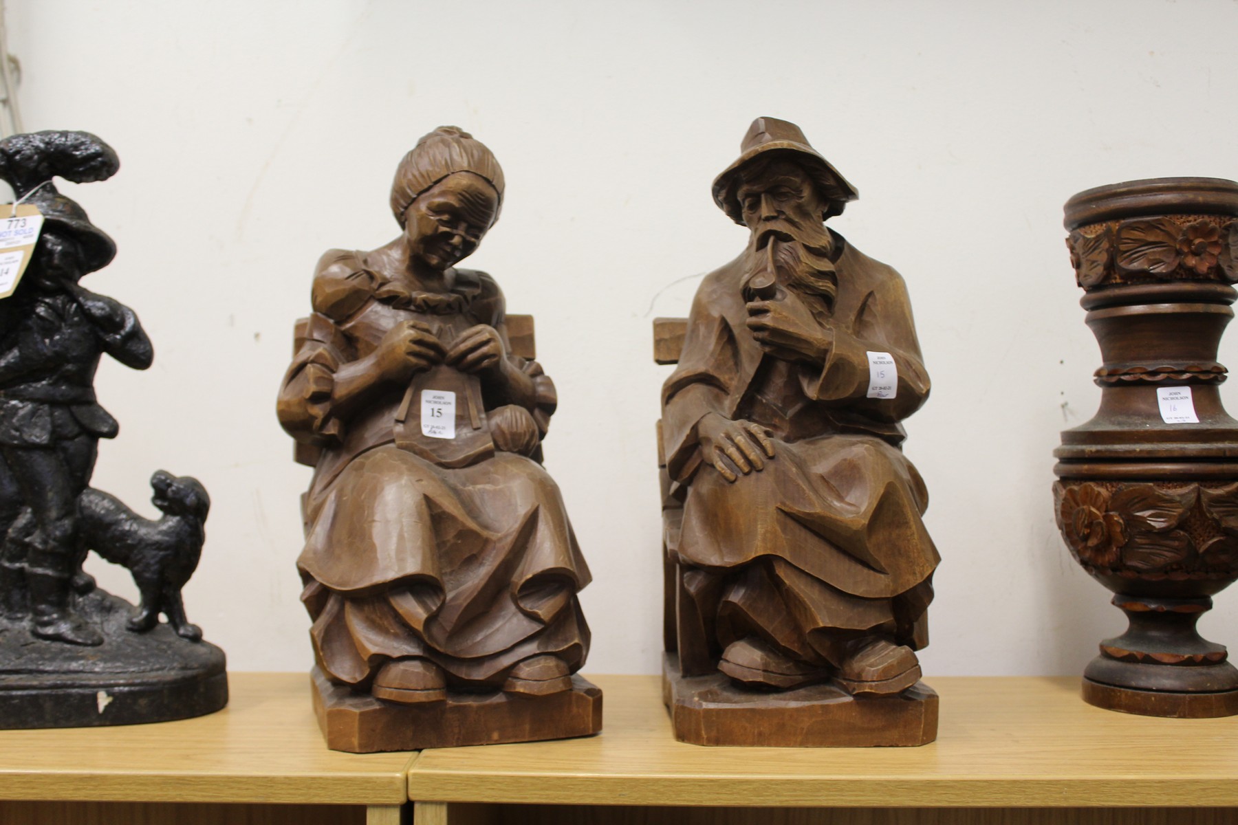 A pair of carved wood seated figures.