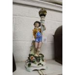 A continental porcelain figure holding a cornucopia of flowers.