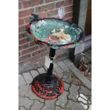 A painted cast metal bird bath.