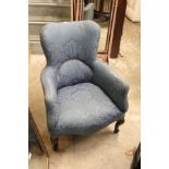 A small blue upholstered armchair.