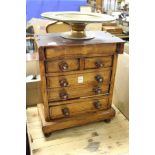A miniature oak chest of drawers.