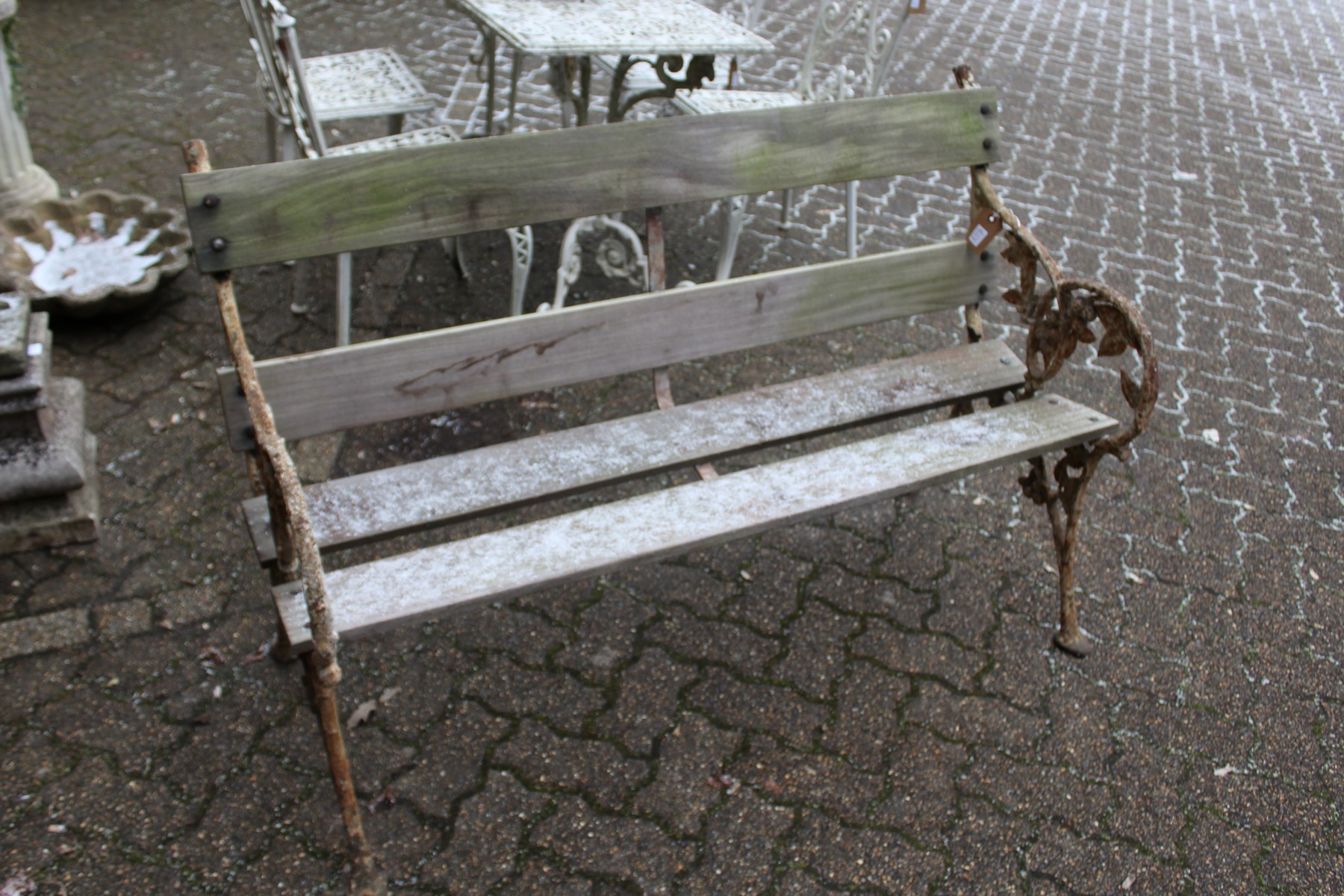 A garden bench with cast iron ends and wooden slatted back and seat.