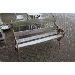A garden bench with cast iron ends and wooden slatted back and seat.