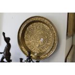 An Arts & Crafts embossed brass circular dish.