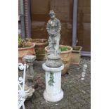 A composite garden classical figure mounted on a fluted pedestal column.