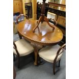 A mahogany oval breakfast table on four carved cabriole legs with claw and ball feet.
