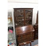 A George III mahogany bureau with associated bookcase top.