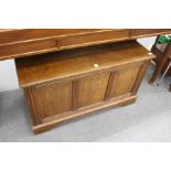 An oak blanket box with panelled front and ends.