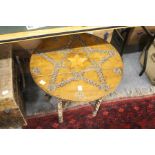 An eastern carved wood circular table on folding stand.