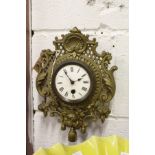 A small ornate brass wall clock.
