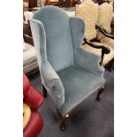 A George III design wing armchair on cabriole legs.