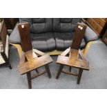 A pair of rustic oak chairs.