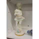 A unusual Royal Worcester part glazed figure of a young girl about to kick a ball.