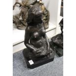 A bronze seated female nude on a marble base.